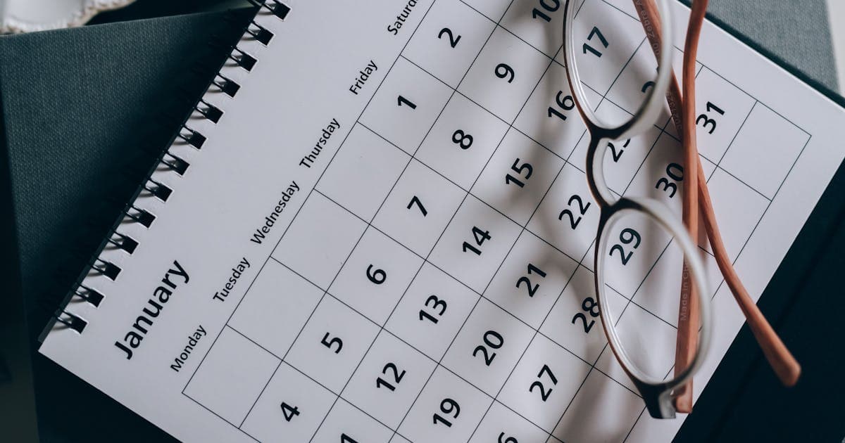 Planner and glasses on a desk for tracking a monthly budget