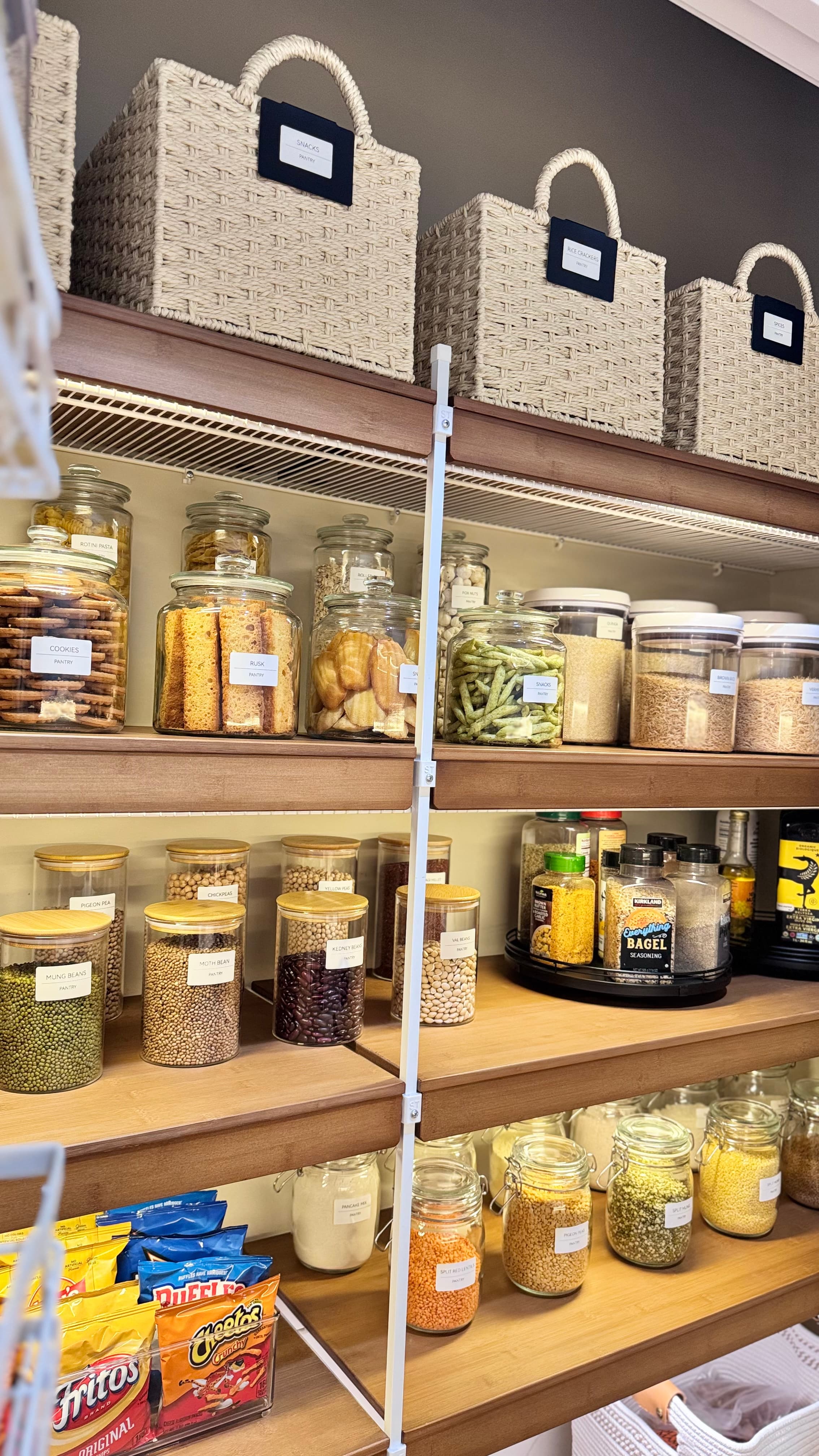 Glass jars with matching wooden lids holding beans, grains, and pasta